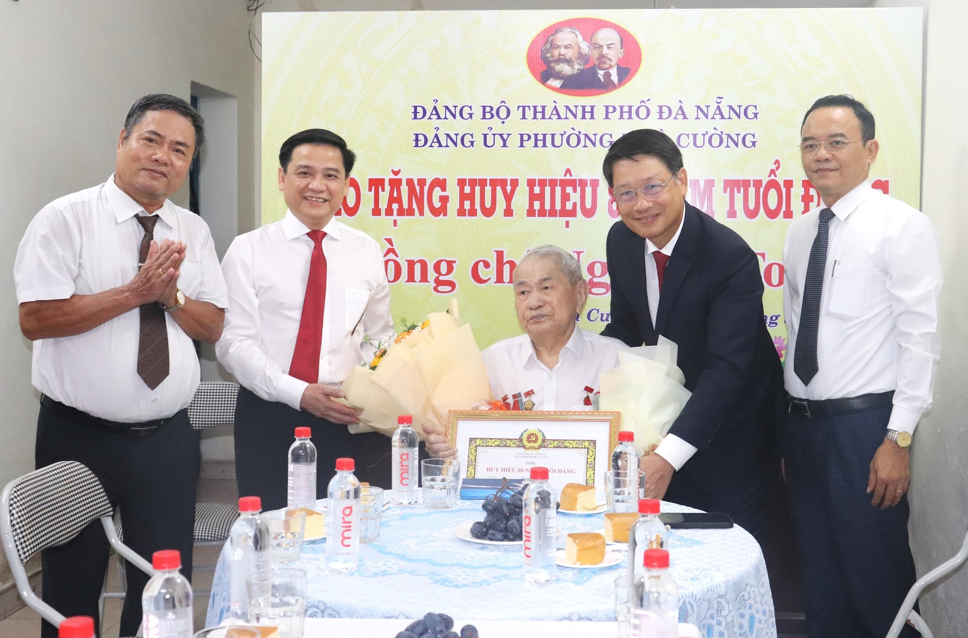 Phó Bí thư Thành ủy Ngô Xuân Thắng (thứ hai, bên phải sang) trao quyết định tặng Huy hiệu 80 năm tuổi Đảng cho đồng chí Nguyễn Toại. Ảnh: NGỌC HÀ
