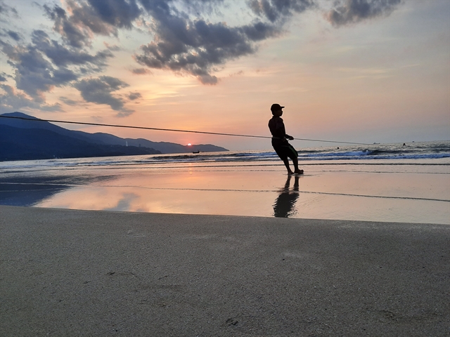 a fisherman pulls a fishing net