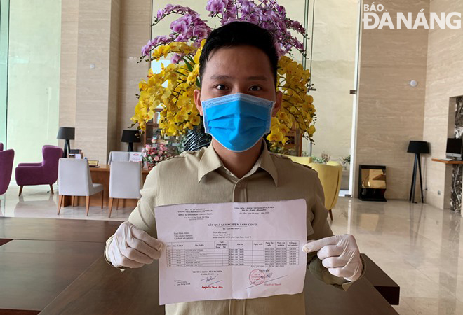a hotel staff member is happy with his negative test result for sars cov 2