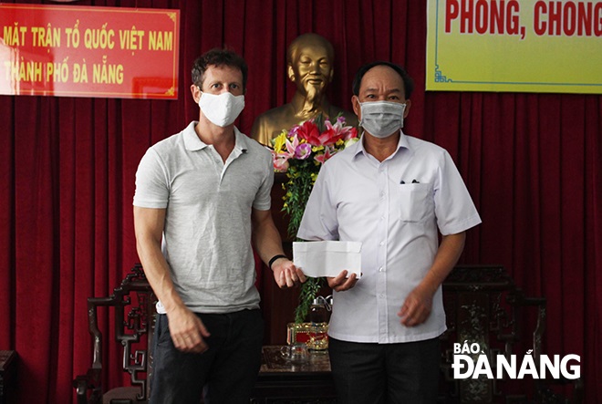 a representative from the da nang fatherland front committee receiving donations from mr mike harris 28left 29