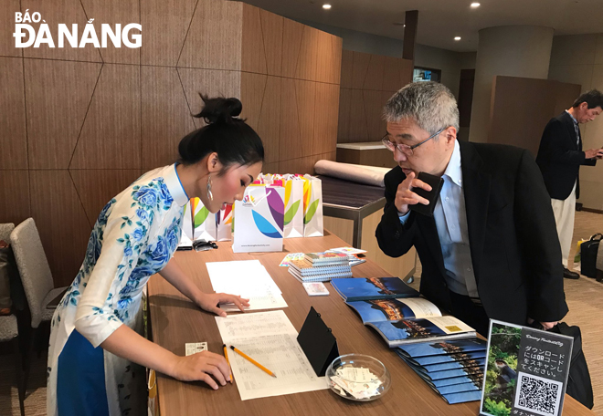 a staff member of the da nang department of tourism promoting the local tourism in japan