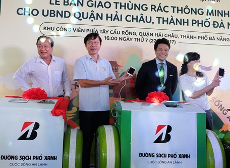 Các đại biểu khách mời thử nghiệm tính năng sạc pin điện thoại tại buổi lễ bàn giao và đưa vào sử dụng 50 thùng rác thông minh cho quận Hải Châu